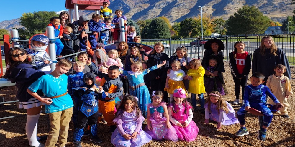 6th graders and kindergarteners in a group picture on the kindergarten playground