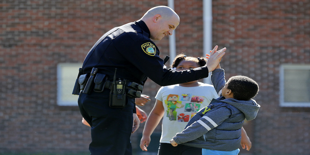 police officer high fiving a child